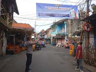 Bhabinkamtibmas Nyamplungan Pasang Banner Himbauan Antisipasi Penipuan di Kawasan Pasar Ikan
